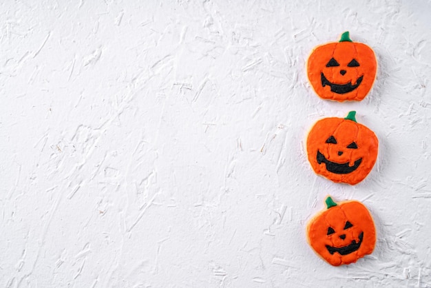 Vista superior de las galletas de azúcar glas decoradas festivas de Halloween sobre fondo blanco