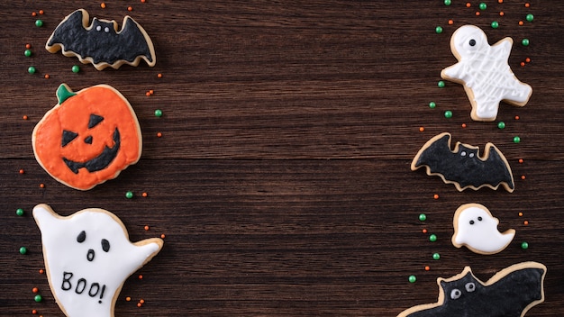 Vista superior de las galletas de azúcar de jengibre glaseado decoradas festivas de Halloween con espacio de copia y diseño plano.