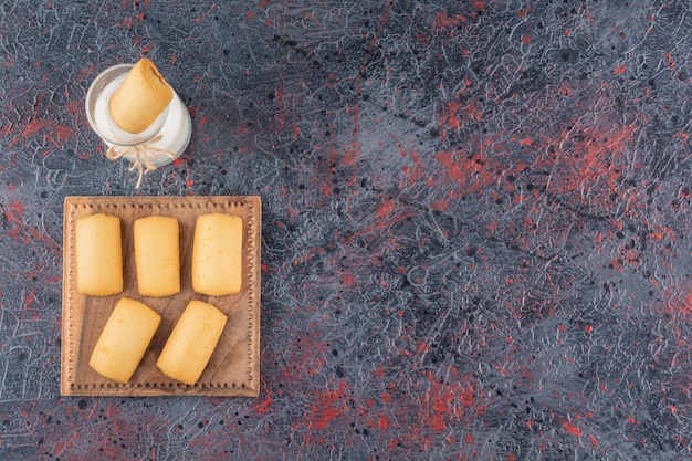 Vista superior de galletas caseras con leche en rústico.