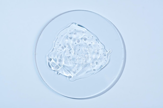 Vista superior de un gel cosmético transparente en una placa de Petri de vidrio sobre un fondo azul Testos de laboratorio de concepto e investigación para hacer cosméticos Espacio de copia