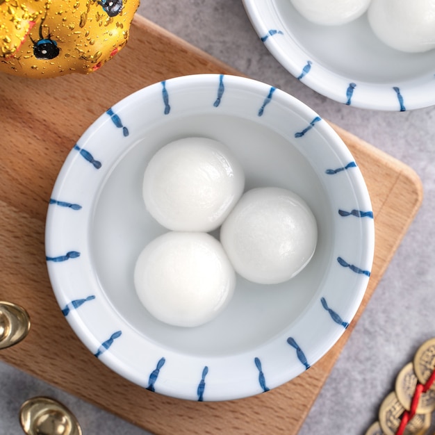 Vista superior del gran tangyuan yuanxiao (bolas de bola de masa de arroz glutinoso) para la comida del festival del año nuevo lunar chino, las palabras en la moneda de oro significan el nombre de la dinastía que hizo.