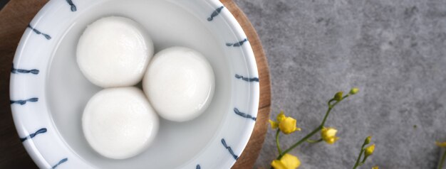 Vista superior del gran tangyuan yuanxiao (bolas de bola de masa de arroz glutinoso) para la comida del festival del año nuevo lunar, las palabras en la moneda de oro significan el nombre de la dinastía que hizo.