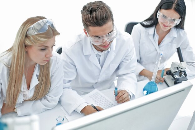 Foto vista superior. un grupo de científicos que trabajan en una computadora en el laboratorio. ciencia y salud