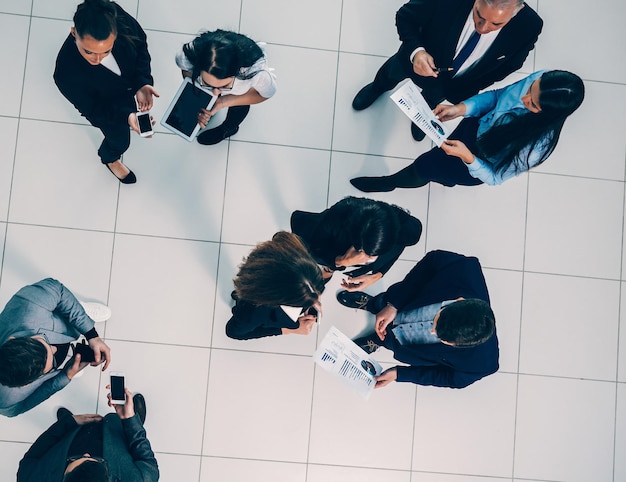 Vista superior. un grupo de empleados discutiendo datos financieros. foto con espacio de copia