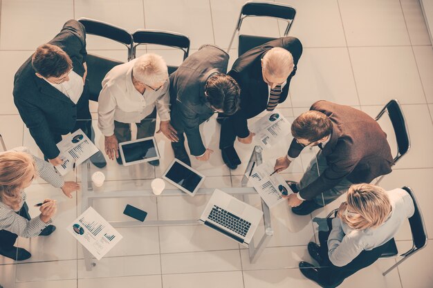 Vista superior. grupo de empleados discutiendo estadísticas financieras.