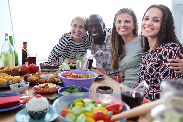 Vista superior del grupo de personas cenando juntos mientras están sentados en la mesa de madera Comida en la mesa La gente come comida rápida