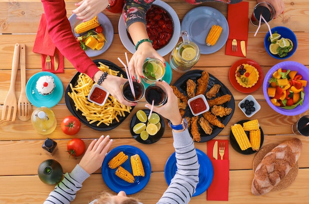 Vista superior grupo de personas cenando juntos mientras están sentados en la mesa de madera