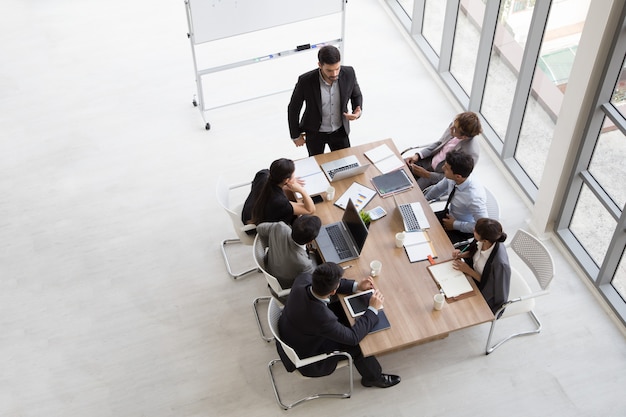 Vista superior del grupo de personas ocupadas multiétnicas que trabajan en una oficina