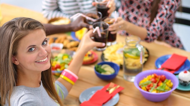 Foto vista superior del grupo de personas que cenan juntos mientras están sentados en la mesa de madera comida en la mesa la gente come comida rápida retrato de una niña