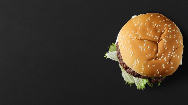 Vista superior de una hamburguesa de carne fresca en fondo negro con espacio de copia Propósito de publicidad IA generativa