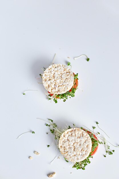 Vista superior Hamburguesa saludable con pan de arroz crujiente verduras tomate y microvegetales