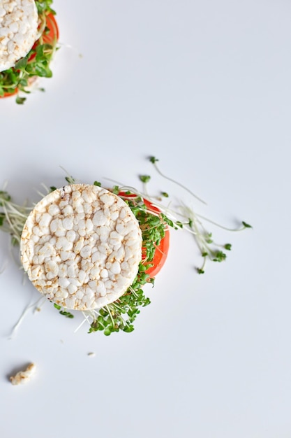 Vista superior Hamburguesa saludable con pan de arroz crujiente verduras tomate y microvegetales