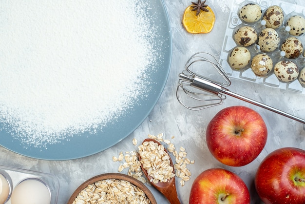 Vista superior de harina blanca con huevos, cereales crudos y semillas sobre fondo blanco pastel de masa semillas pastel de leche callos de color