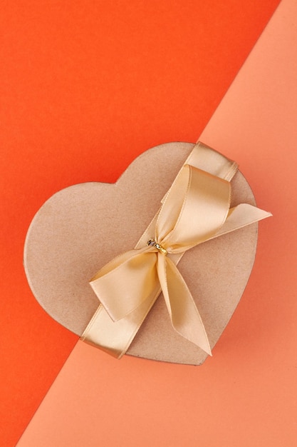 Vista superior de la hermosa caja de regalo en forma de corazón sobre fondo de color