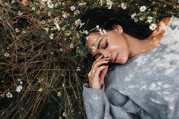 Vista superior de una hermosa joven morena al aire libre disfrutando de la naturaleza Retrato horizontal de una atractiva mujer caucásica siéntete libre y sueña en el prado con espacio para copiar Idea de portada moodxA