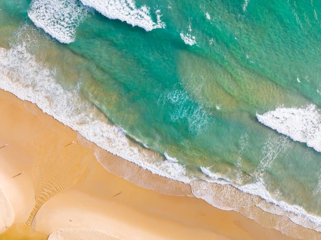 Vista superior hermosa playa con olas rompiendo en la orilla arenosa Increíble superficie del mar a orillas del mar Increíble hermosa playa de arena Naturaleza y antecedentes de viajes