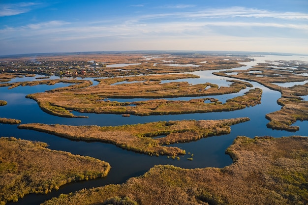 Vista superior de la hermosa Samarskie Plavni en el Dnieper con un pueblo cercano en la cálida luz del atardecer