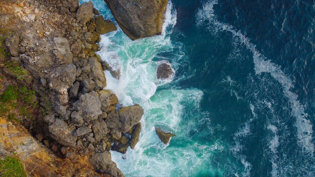 Vista superior de hermosas olas rompiendo los acantilados