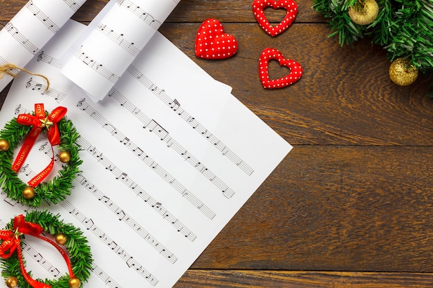 Vista superior de hoja de música de papel de nota y decoración de Navidad sobre fondo de madera