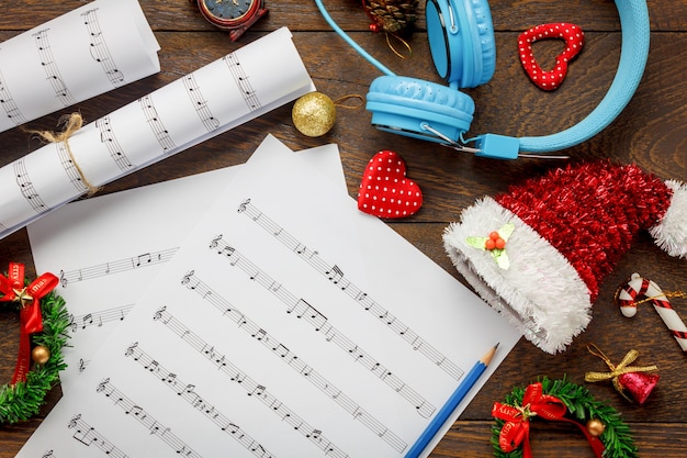 Vista superior de hoja de música de papel de nota y decoración de Navidad sobre fondo de madera