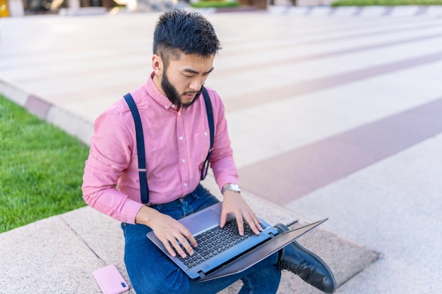 Vista superior de un hombre asiático usando una computadora portátil