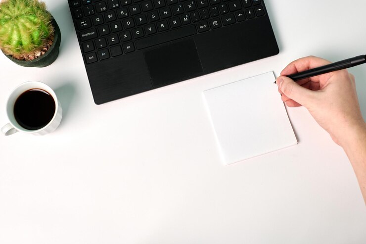Vista superior de un hombre escribiendo con un bolígrafo en un papel en blanco sobre un fondo blanco. Copie el espacio, concepto de negocio