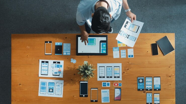 Foto vista superior de un hombre de negocios cualificado mirando y eligiendo el diseño de ux ui convocación