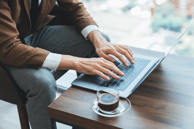 Vista superior de un hombre de negocios inteligente trabajando a mano escribiendo usando una computadora portátil Ornamentado