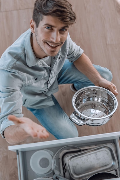 Vista superior de un hombre sacando utensilios de la mesa de la cocina