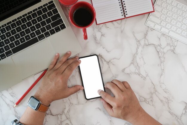 Vista superior hombre usando teléfono móvil inteligente en el espacio de trabajo