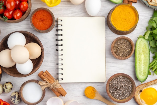 Foto vista superior huevos blancos frescos con verduras y condimentos sobre fondo blanco comida color maduro almuerzo comida ensalada desayuno