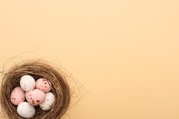 Vista superior de huevos de codorniz rosados y blancos sobre fondo beige