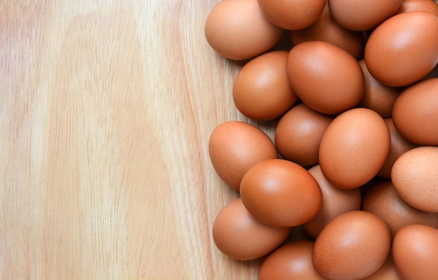 Foto vista superior de huevos de gallina marrón sobre fondo de madera