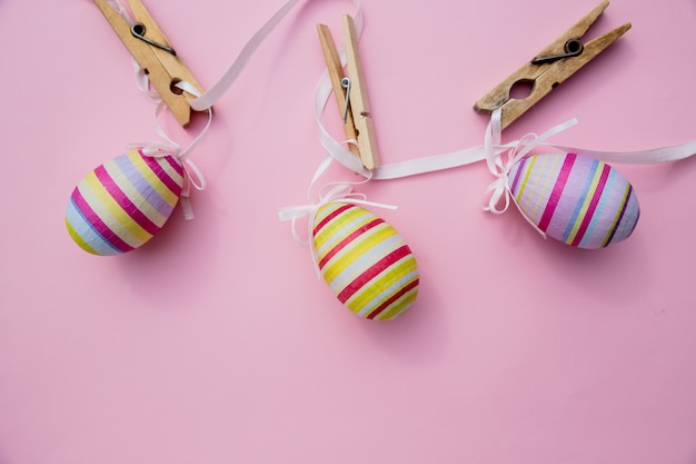 Foto vista superior de los huevos de pascua coloreados con pintura rosa en diferentes patrones