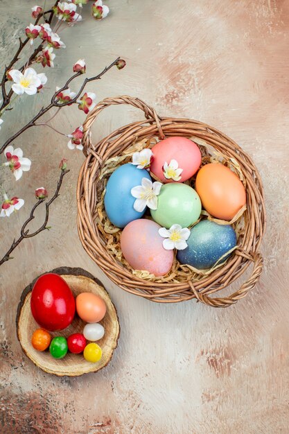 Vista superior de los huevos de pascua de colores dentro de la canasta sobre fondo marrón vacaciones de Pascua ornamentado horizontal colorido