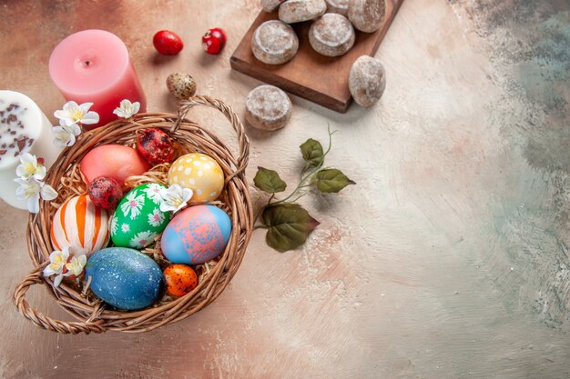 Vista superior de huevos de pascua de colores dentro de la canasta sobre una superficie ligera