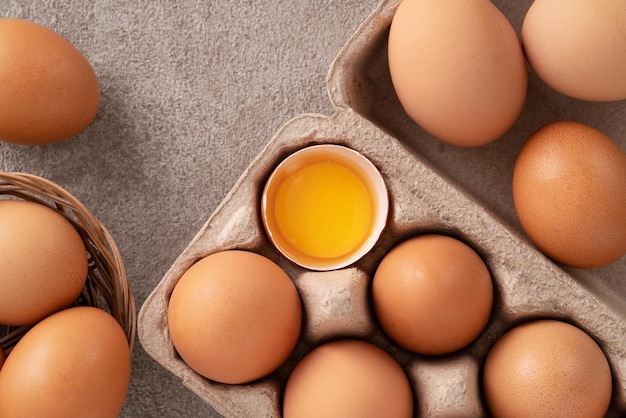 Vista superior de huevos de pollo marrones frescos en un plato sobre fondo de mesa gris