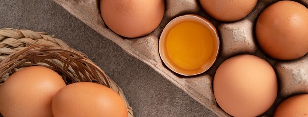 Vista superior de huevos de pollo marrones frescos en un plato sobre fondo de mesa gris