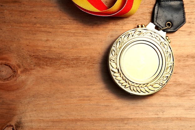 Foto vista superior de la imagen de la medalla de oro sobre fondo de madera