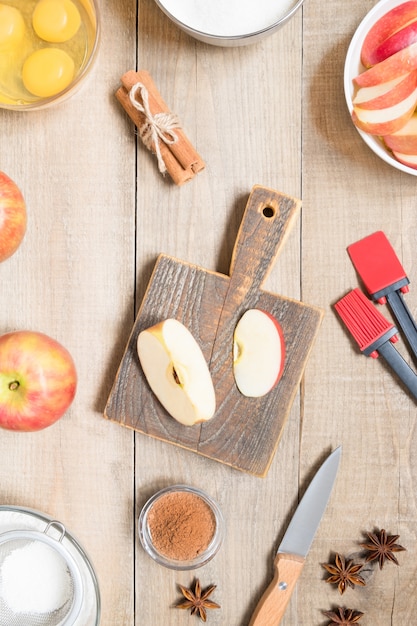 Vista superior de ingredientes crudos para cocinar tarta de manzana sobre fondo de madera