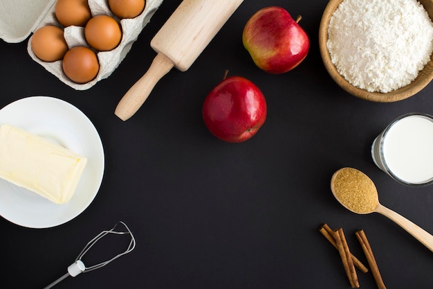 Vista superior de los ingredientes para hacer pastel de manzana o pastel en el fondo negro Copiar espacio