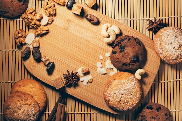 Vista superior de los ingredientes de nueces de galletas dulces crujientes redondas sobre fondo de tabla de cortar de madera