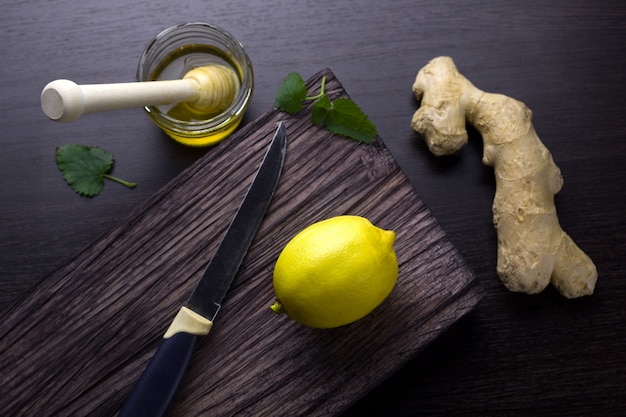 Vista superior de jengibre, limón, miel sobre una tabla de madera