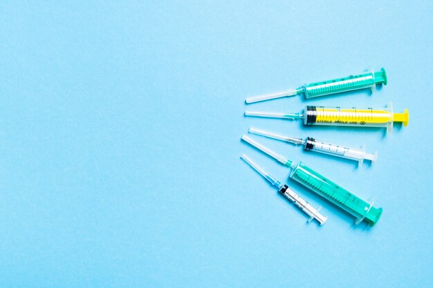 Foto vista superior de jeringas médicas con agujas en azul