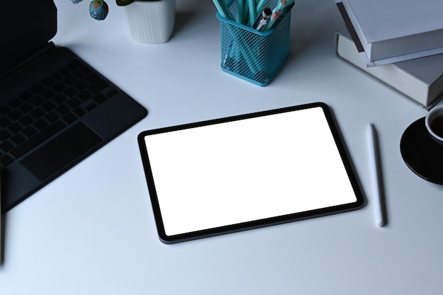 Vista superior del lápiz óptico de la tableta digital y papelería en la mesa blanca