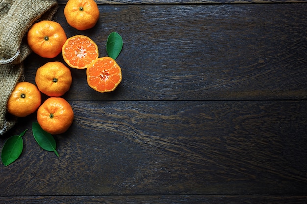 Vista superior laranja cortada em madeira rústica e saco com espaço de cópia.