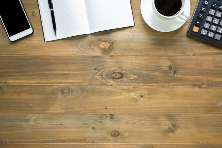 Foto vista superior de la libreta en blanco en el escritorio de oficina de madera con teléfono inteligente, calculadora y taza de café