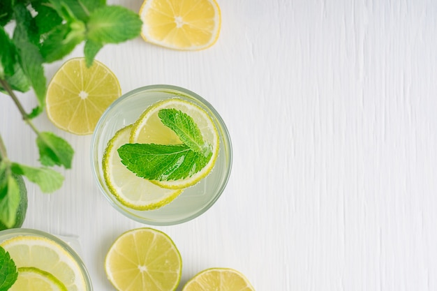 Vista superior de limonada refrescante hecha de rodajas de limón y lima agua con gas y hojas de menta verde