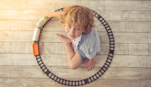 Vista superior del lindo niño jugando con tren de juguete