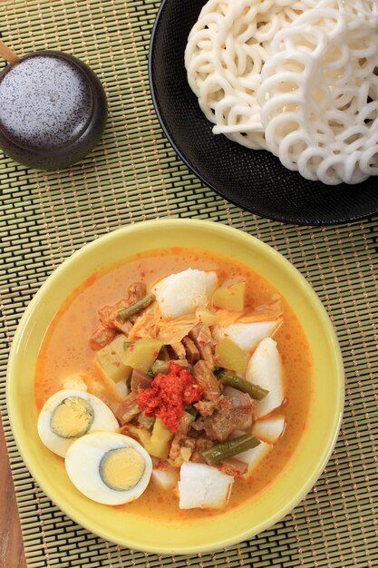 Vista superior Lontong Sayur Padang, curry de verduras con pastel de arroz prensado, servido con huevo cocido